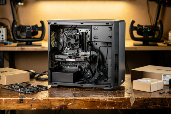 Budget flight sim PC build in progress on a workbench with parts boxes and a yoke