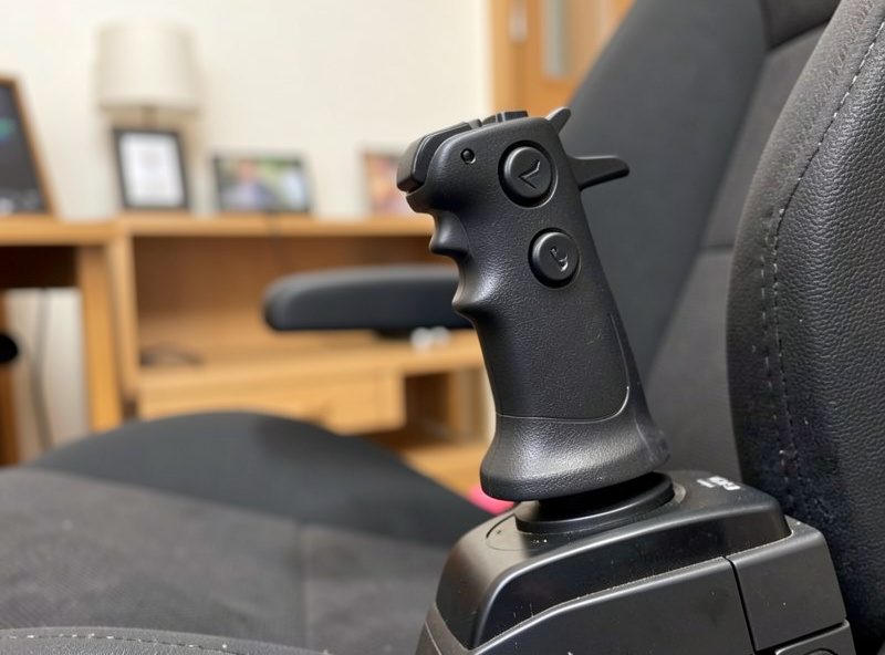 Close-up of a HOTAS sidestick grip with thumb buttons, mounted to the right of the seat for Airbus-style flying
