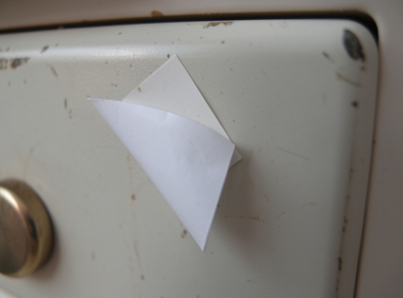 Close-up of peeling label-maker tape on a flight sim button box panel